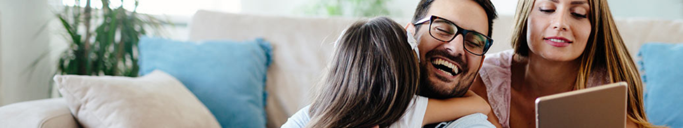 Family on couch, mom holding tablet